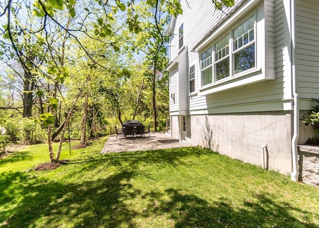 view of green lawn featuring a patio area
