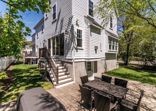 view of patio / terrace featuring stairs, outdoor dining area, and a wooden deck