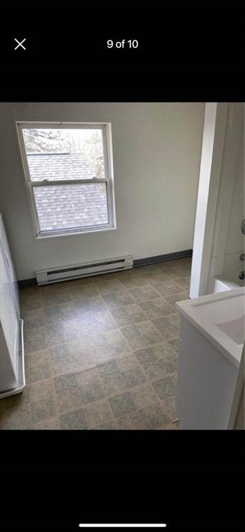 57 Beacon St, North Adams, MA 01247 - unfurnished room featuring baseboard heating, healthy amount of natural light, and tile patterned floors