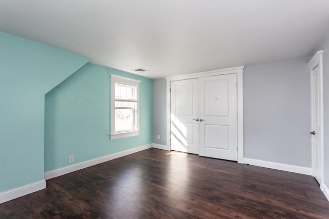 bonus room featuring dark wood-type flooring, baseboards, and visible vents