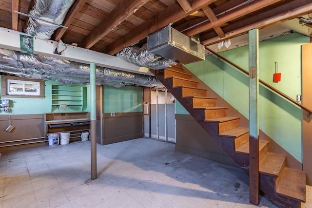 unfinished basement with stairs and tile patterned floors