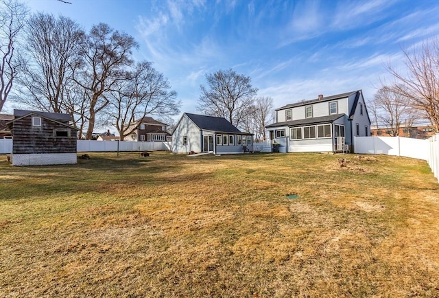 exterior space featuring a yard, a fenced backyard, and a sunroom