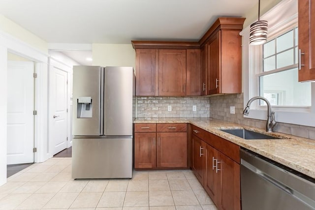 kitchen with tasteful backsplash, light stone countertops, light tile patterned floors, appliances with stainless steel finishes, and a sink