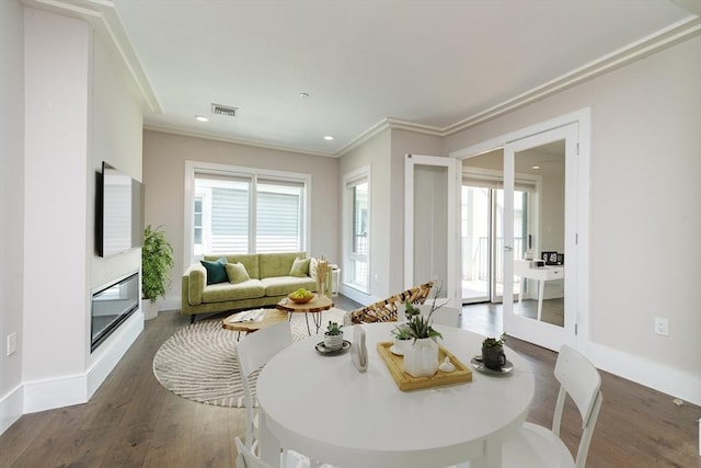 dining area with ornamental molding and dark hardwood / wood-style floors