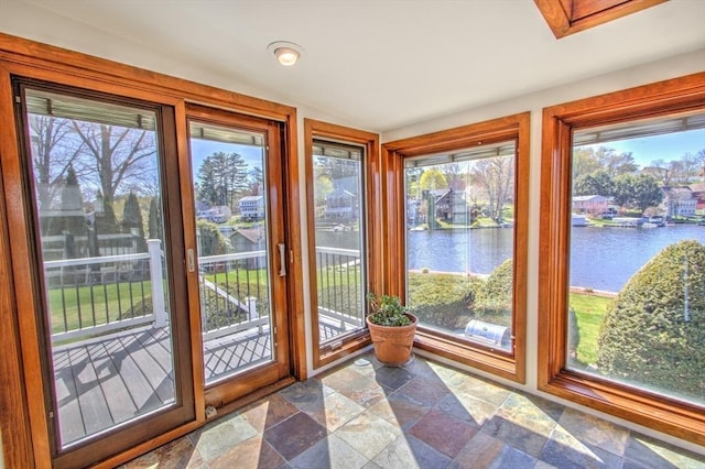 doorway to outside featuring a water view and stone finish floor