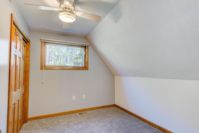 additional living space with visible vents, carpet floors, lofted ceiling, baseboards, and ceiling fan