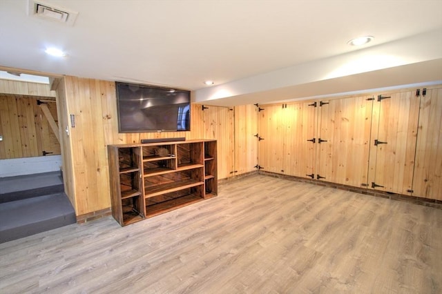 finished basement with recessed lighting, wood walls, wood finished floors, and visible vents