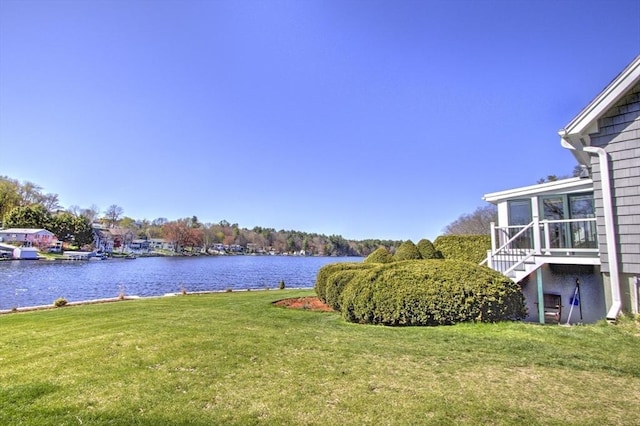 view of yard featuring a water view and stairs