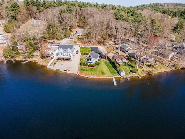 birds eye view of property with a water view and a wooded view