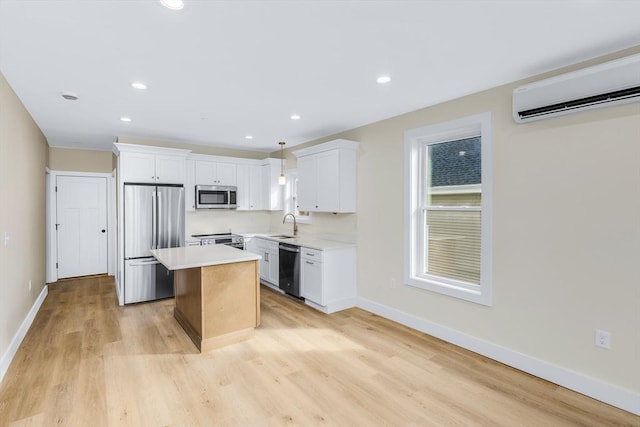 kitchen with white cabinetry, an AC wall unit, appliances with stainless steel finishes, light countertops, and a center island