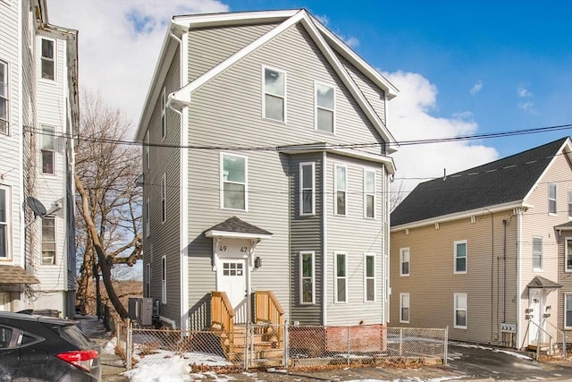 view of front of home featuring fence and central AC unit