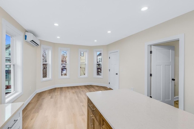 interior space with light countertops, a wall mounted AC, and a wealth of natural light