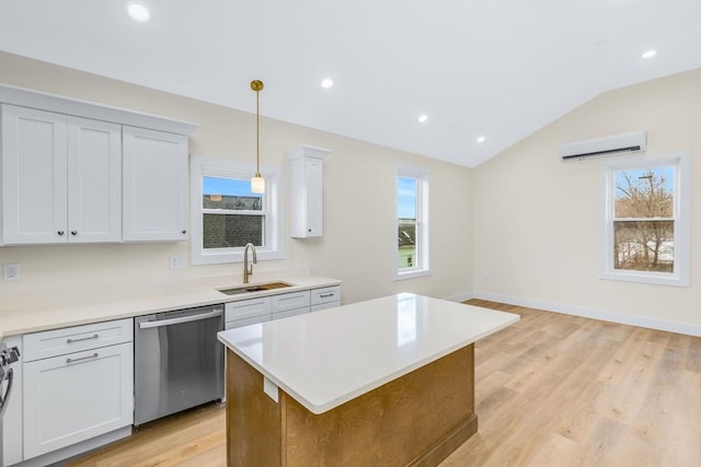 kitchen with lofted ceiling, a sink, an AC wall unit, stainless steel dishwasher, and a wealth of natural light