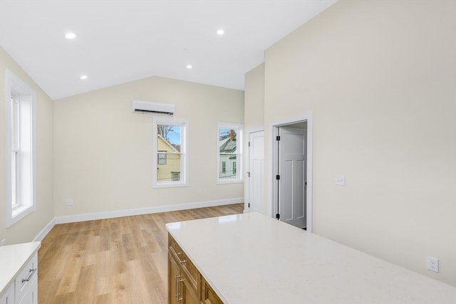 kitchen featuring lofted ceiling, a wall mounted air conditioner, light countertops, light wood-type flooring, and recessed lighting