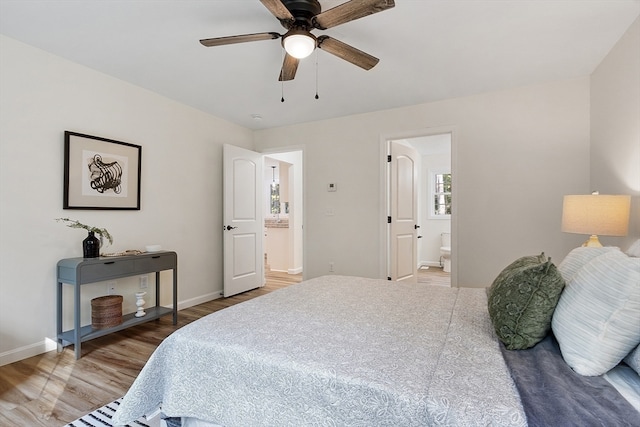 bedroom with ceiling fan, wood-type flooring, and connected bathroom