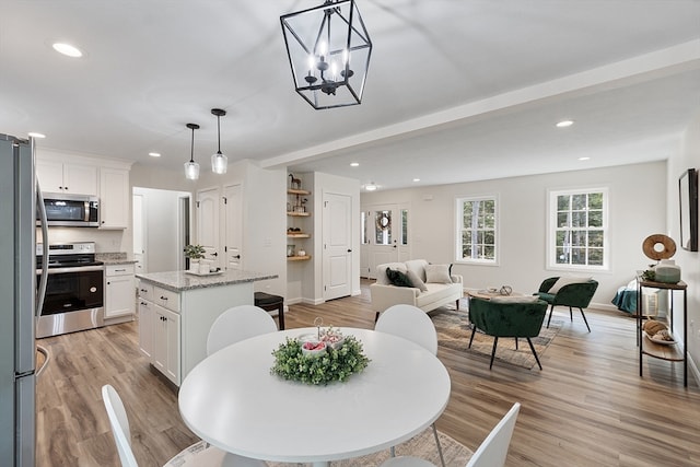 dining area featuring light wood-type flooring and a chandelier