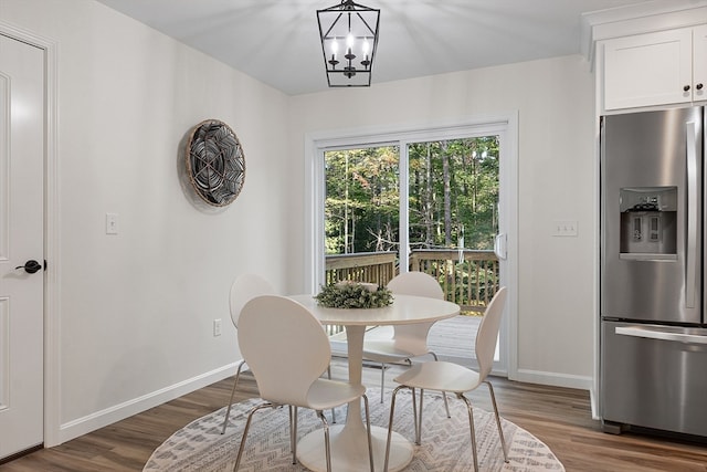 dining area with hardwood / wood-style floors and a notable chandelier