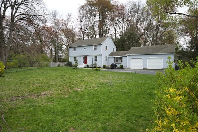 9 Brucewood, Acton, MA 01720 - colonial house featuring fence, an attached garage, a front lawn, aphalt driveway, and a chimney