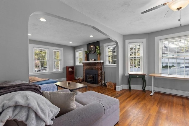 living room with ceiling fan, arched walkways, recessed lighting, baseboards, and wood finished floors
