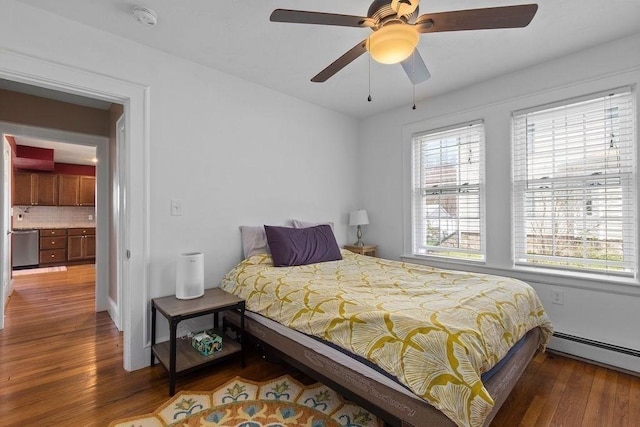 bedroom featuring a ceiling fan, a baseboard heating unit, and hardwood / wood-style floors