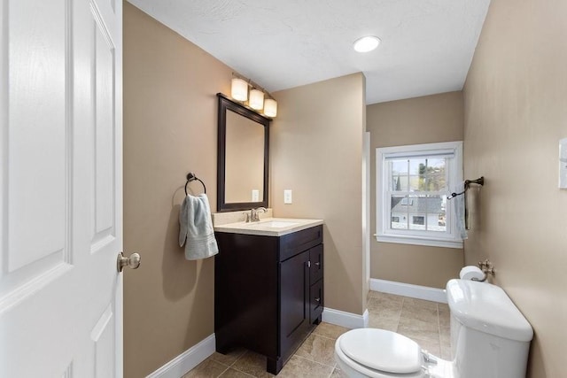 bathroom featuring vanity, tile patterned flooring, baseboards, and toilet