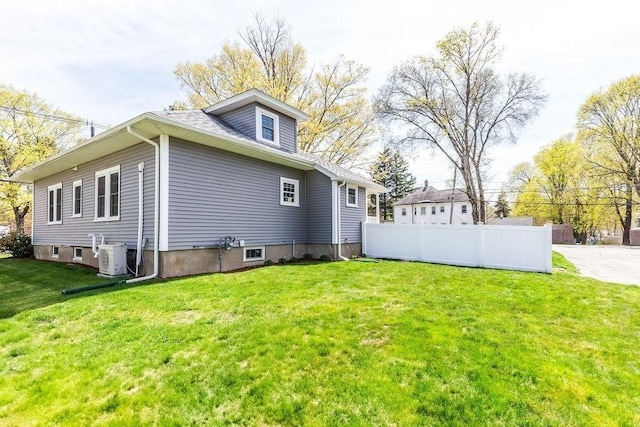 back of house featuring a yard, fence, and ac unit