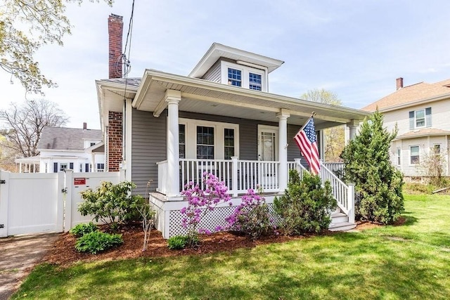 bungalow-style house featuring a porch, a chimney, a front yard, a gate, and fence