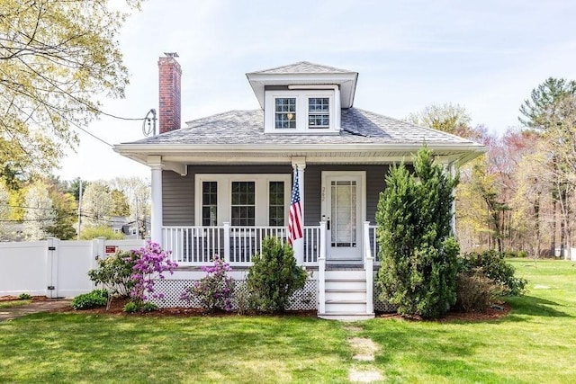 bungalow-style house with fence, a front yard, a gate, a chimney, and covered porch