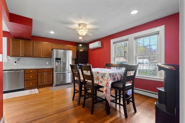 dining area featuring baseboard heating, light wood finished floors, a ceiling fan, recessed lighting, and a wall unit AC