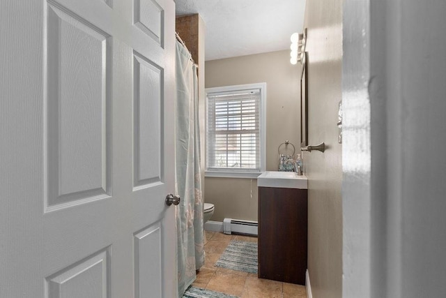 full bathroom featuring vanity, baseboard heating, and toilet
