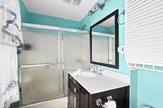 full bathroom featuring vanity, toilet, and combined bath / shower with glass door