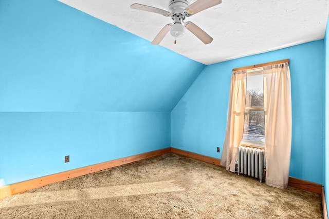 additional living space with radiator, vaulted ceiling, ceiling fan, and carpet flooring