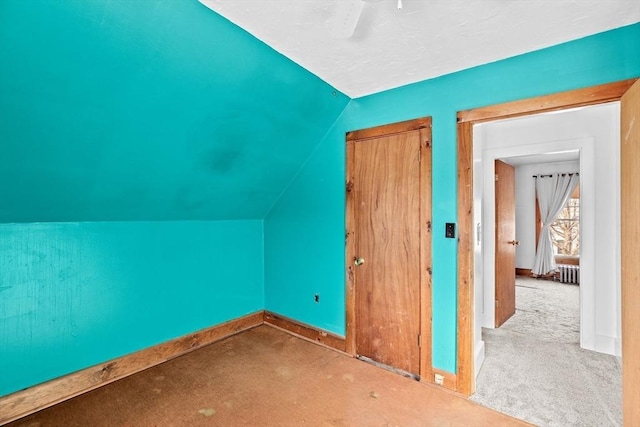 additional living space featuring lofted ceiling and carpet flooring