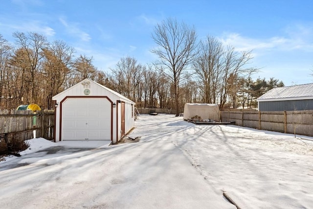 yard covered in snow with a garage and an outbuilding