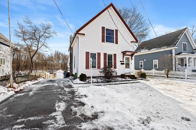 snow covered back of property with a storage shed