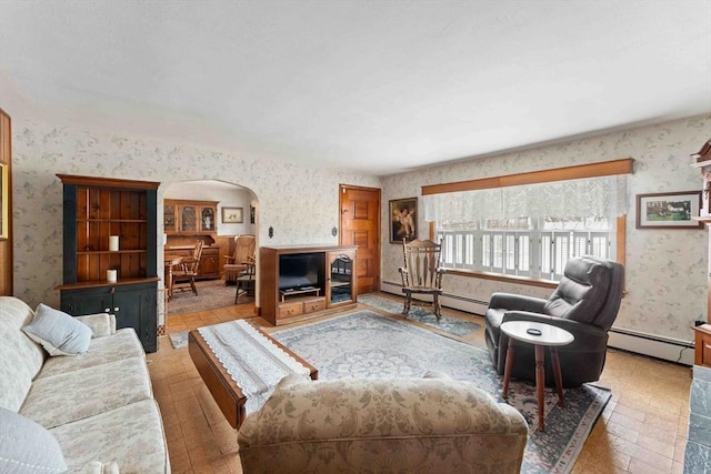 living room featuring wallpapered walls, arched walkways, and a baseboard heating unit