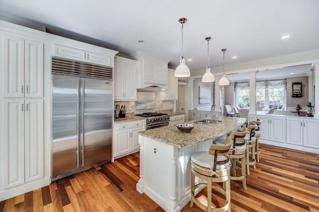 11 Teal Cir, Mashpee, MA 02649 - kitchen featuring premium appliances, light wood-style floors, white cabinetry, an island with sink, and recessed lighting