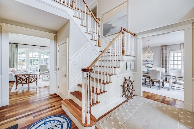 11 Teal Cir, Mashpee, MA 02649 - stairway with wood finished floors, a decorative wall, a wainscoted wall, and a chandelier