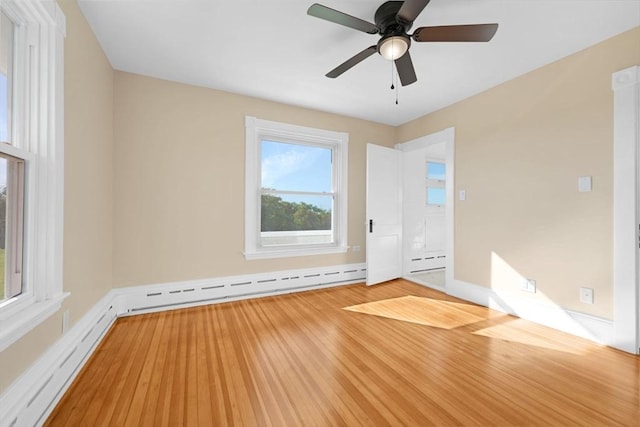 unfurnished room with a baseboard radiator, ceiling fan, baseboards, and wood finished floors