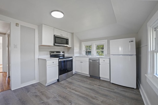 kitchen with stainless steel appliances, dark wood-type flooring, light countertops, and white cabinets