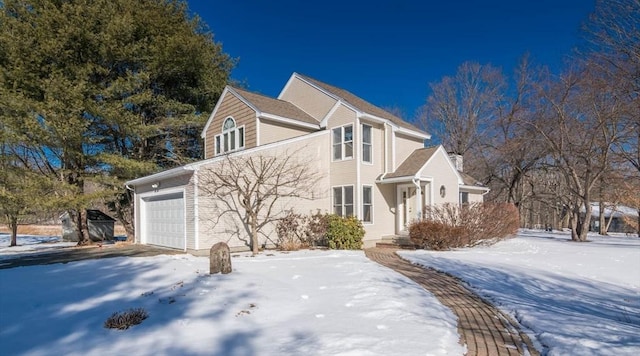 snow covered property with a garage