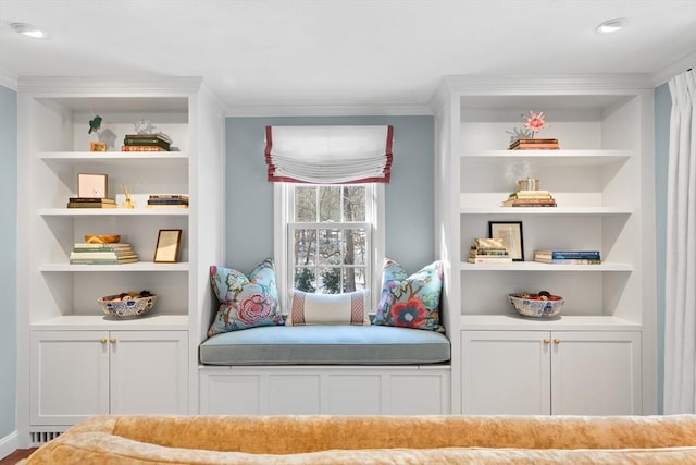 living area featuring crown molding and built in features