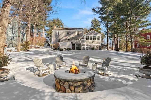 snow covered property with an outdoor fire pit