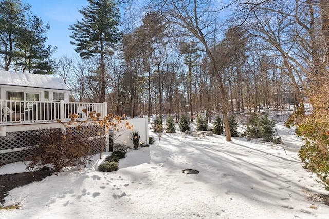 yard covered in snow with a wooden deck