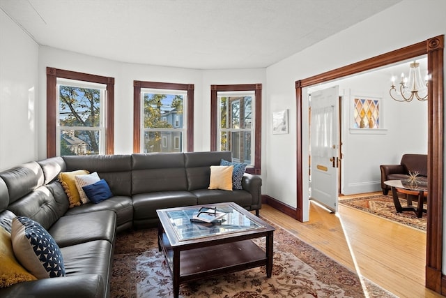 living room with hardwood / wood-style flooring, a healthy amount of sunlight, and a chandelier