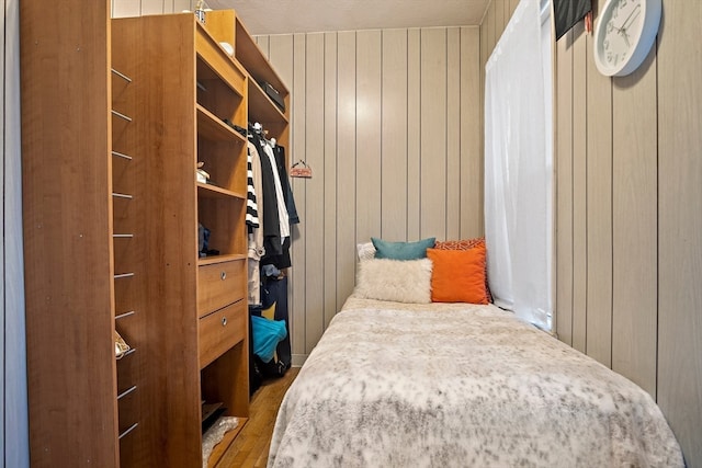 bedroom featuring wood-type flooring and wooden walls