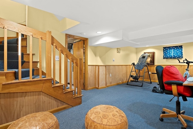 workout room with carpet and wooden walls