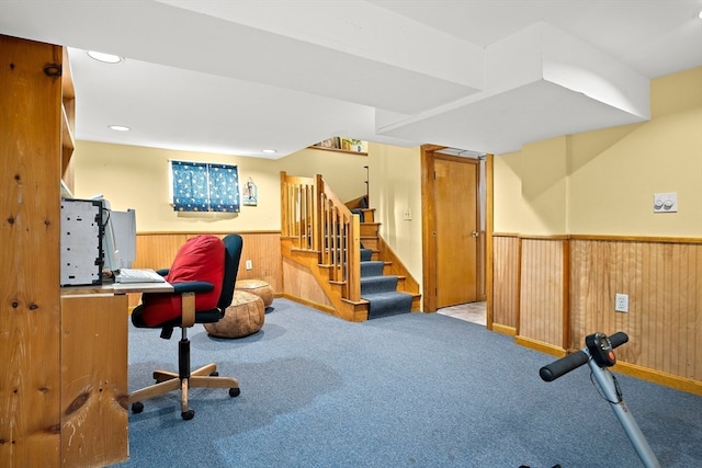 carpeted office featuring wood walls