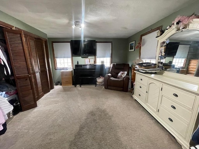 carpeted bedroom with a textured ceiling and a closet