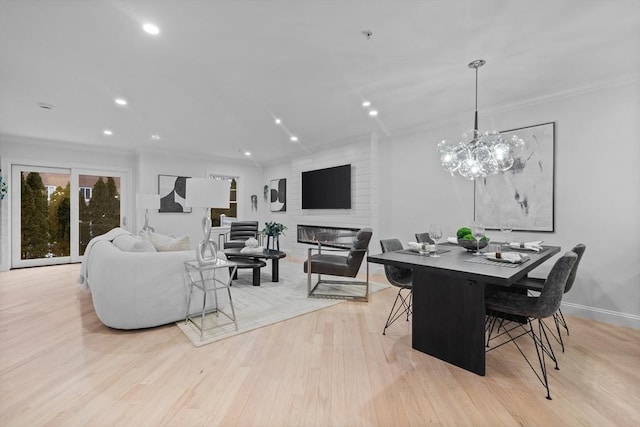 dining area with ornamental molding and light hardwood / wood-style flooring